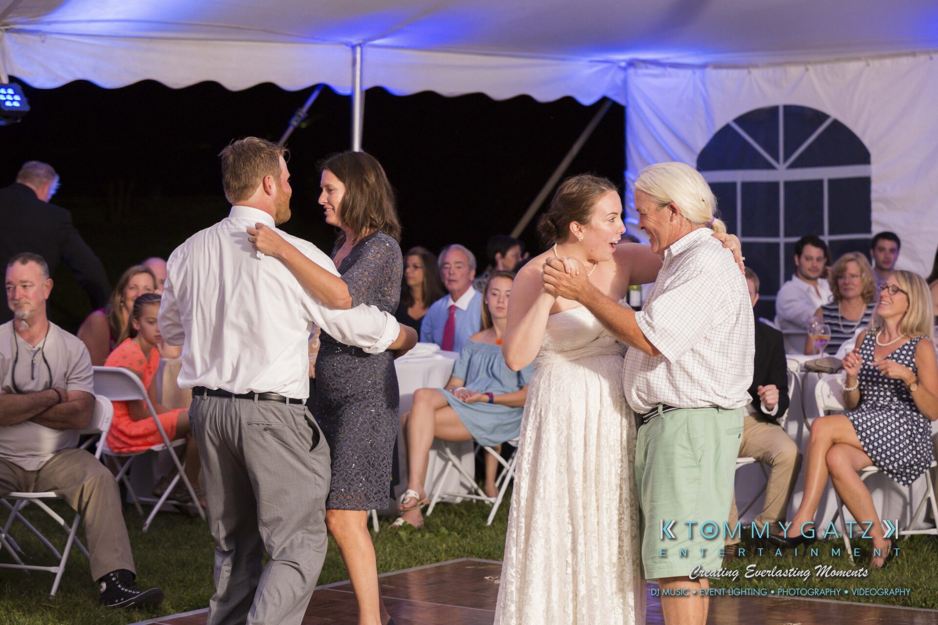 Ann-Marie-Alex-92317-RECEPTION-Low-Res-WM-71 - TOMMY GATZ ENTERTAINMENT Two couples dance on a wooden floor under a white tent, surrounded by seated guests.