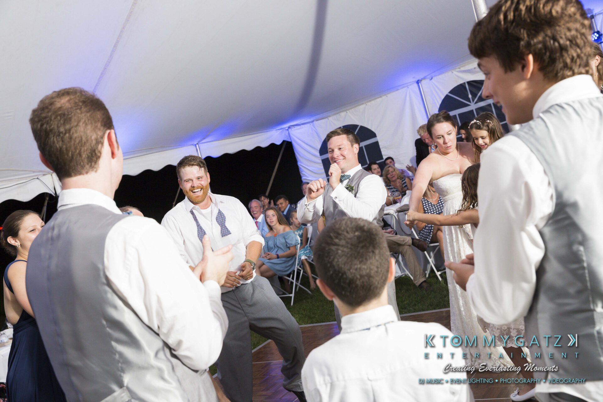 Ann-Marie-Alex-92317-RECEPTION-Low-Res-WM-79 - TOMMY GATZ ENTERTAINMENT People dancing and clapping at an outdoor party under a white tent.