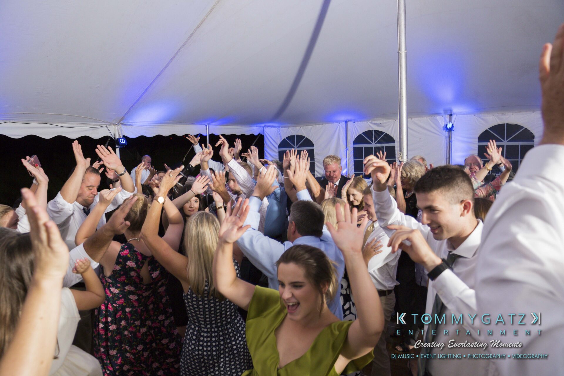 Ann-Marie-Alex-92317-RECEPTION-Low-Res-WM-91 - TOMMY GATZ ENTERTAINMENT People are dancing with hands raised under a white tent at a party or event.