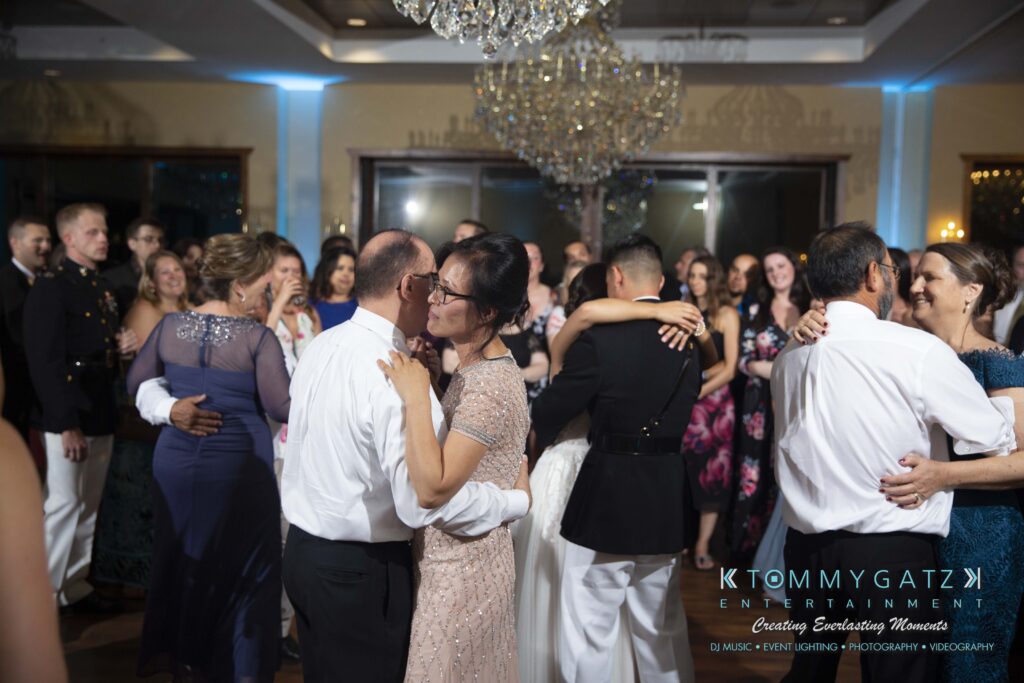 Annie-Casey-060918-RECEPTION-Low-Res-WM-1060 - TOMMY GATZ ENTERTAINMENT Guests dancing in pairs at a formal event; a chandelier is overhead and a crowd watches in the background.