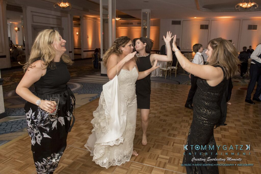 Elizabeth-Tom-101417-RECEPTION-Low-Res-WM-308 - TOMMY GATZ ENTERTAINMENT Women dancing together on a wooden dance floor in a large, elegantly decorated room.