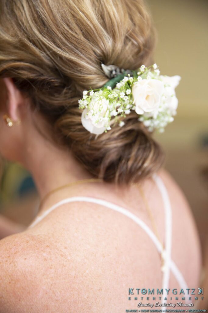 Grace-Michael-063018-PREP-Low-Res-WM-48 - TOMMY GATZ ENTERTAINMENT A woman with blonde hair tied in an updo, decorated with white flowers and baby's breath, wears a thin strap top.