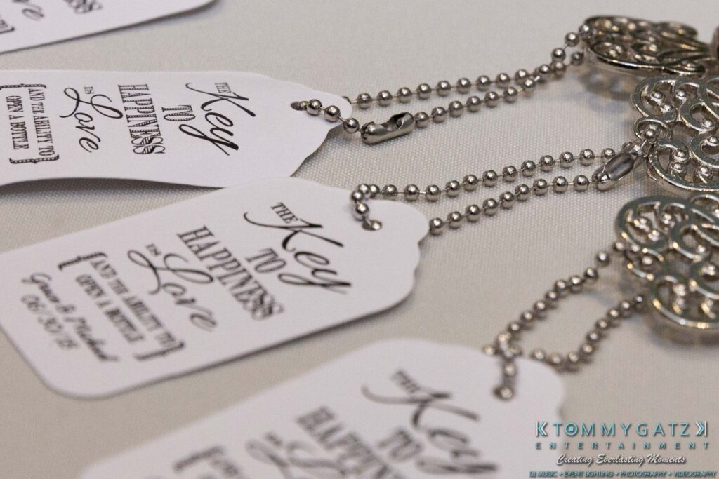 Grace-Michael-063018-RECEPTION-Low-Res-WM-498 - TOMMY GATZ ENTERTAINMENT Close-up of decorative key-shaped wedding favors with tags reading "The Key to Happiness is Love.