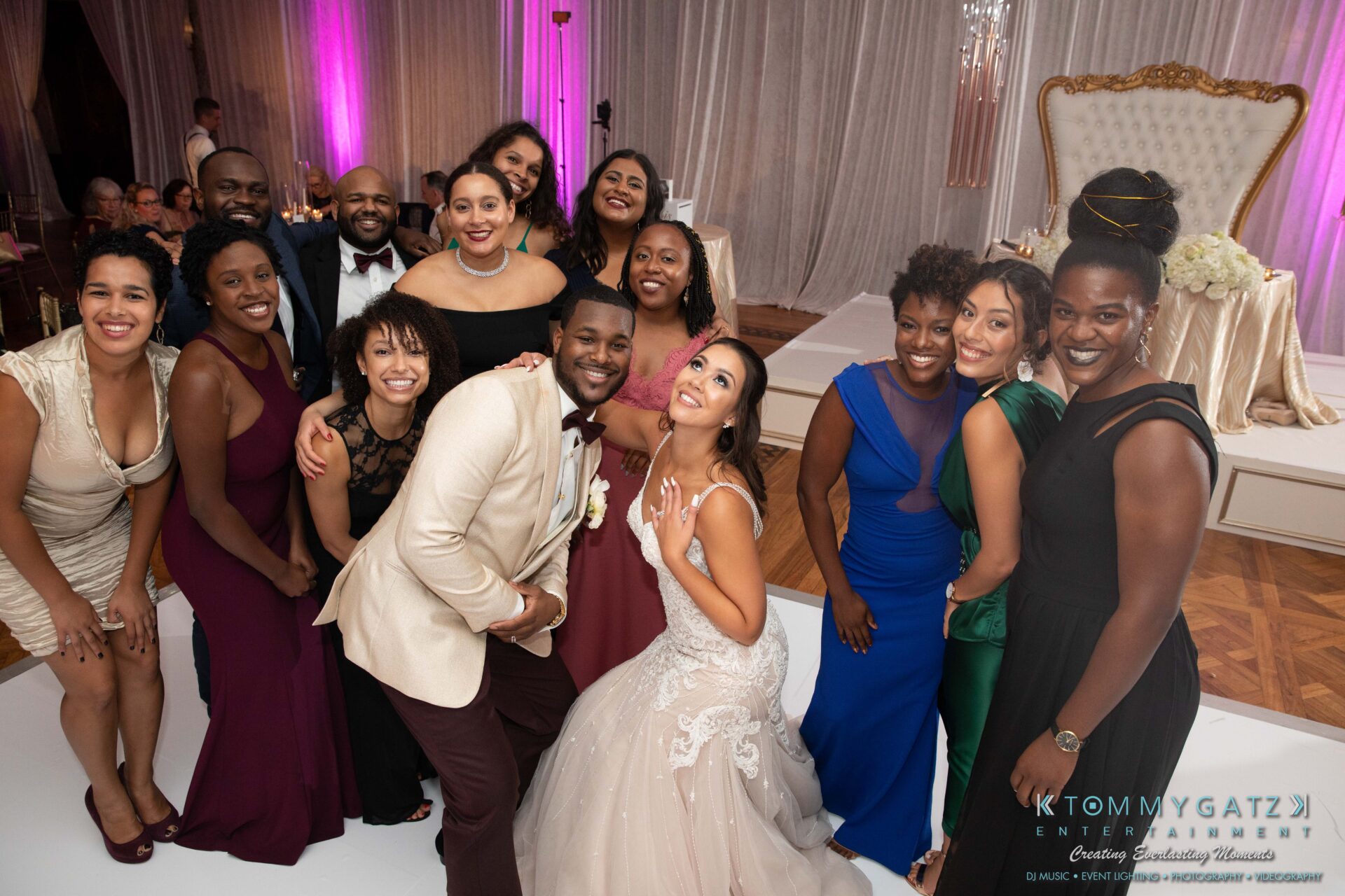 Harris-Wedding-HIGHLIGHTS-090119-107 - TOMMY GATZ ENTERTAINMENT A group of people dressed in formal attire posing together at an indoor event.