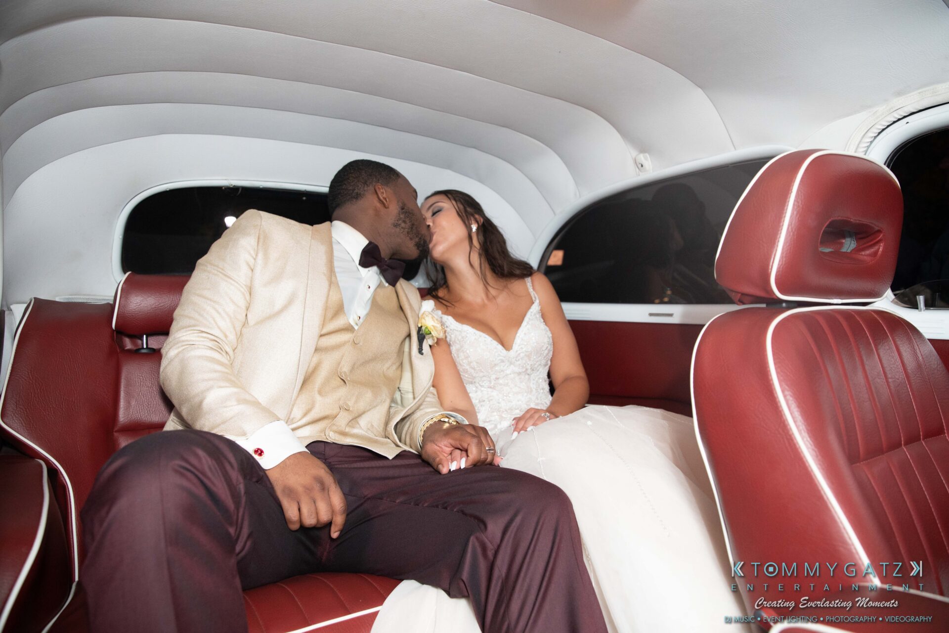 Harris-Wedding-HIGHLIGHTS-090119-128 - TOMMY GATZ ENTERTAINMENT A couple in wedding attire shares a kiss in the backseat of a car.