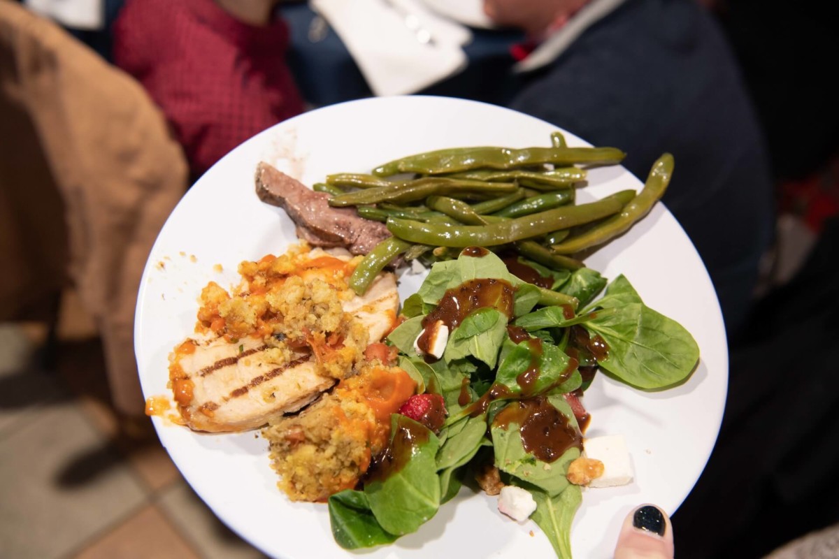 Heather-Scott-Wedding-Low-Res-131 1 - TOMMY GATZ ENTERTAINMENT A plate of grilled chicken with stuffing, green beans, and a salad with spinach, tomatoes, and dressing.