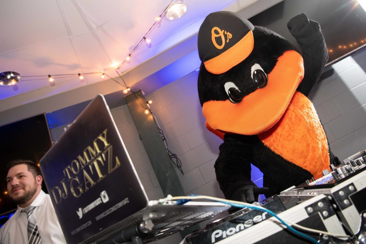Heather-Scott-Wedding-Low-Res-140 1 - TOMMY GATZ ENTERTAINMENT A person in a bird mascot costume DJs at a turntable, next to a man in a suit.