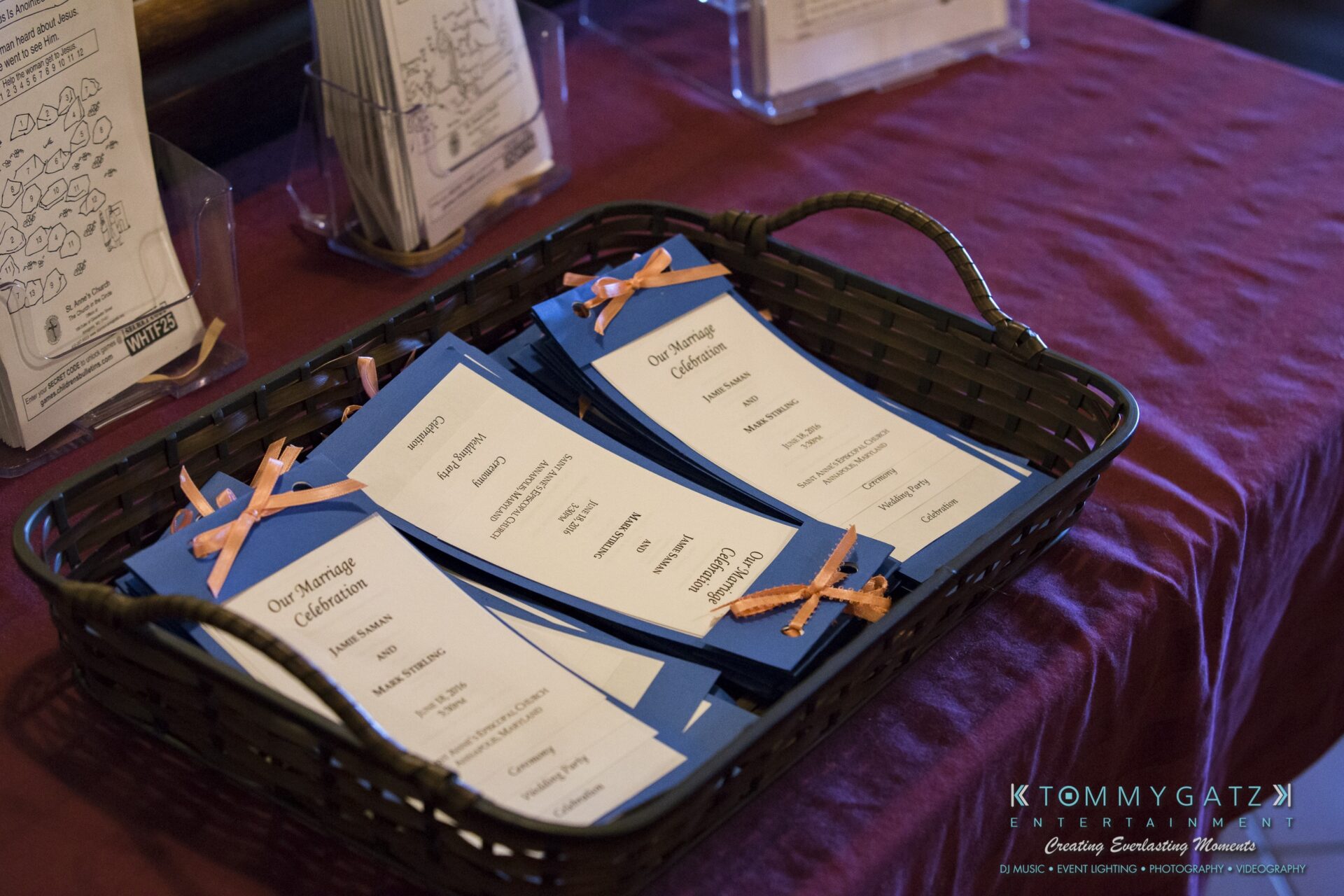 Jamie-and-Mark-Low-Res-Watermark-222 - TOMMY GATZ ENTERTAINMENT A basket with blue and white wedding programs tied with peach ribbons.