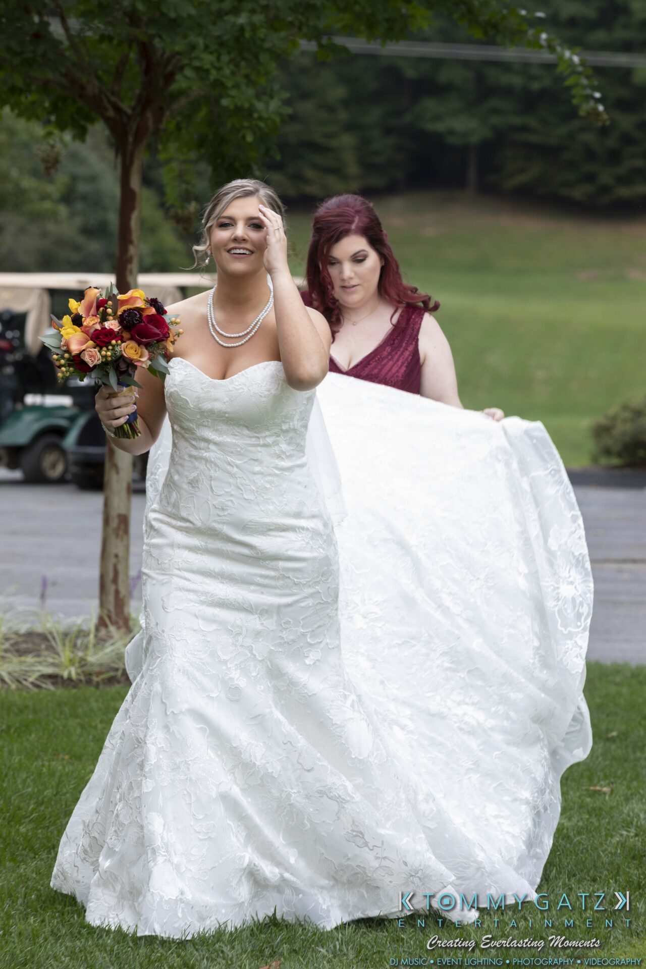 Lisa-Robert-092218-BLOG-selections-WM-21 - TOMMY GATZ ENTERTAINMENT A bride holds a bouquet while a bridesmaid adjusts the train of her wedding dress outdoors.