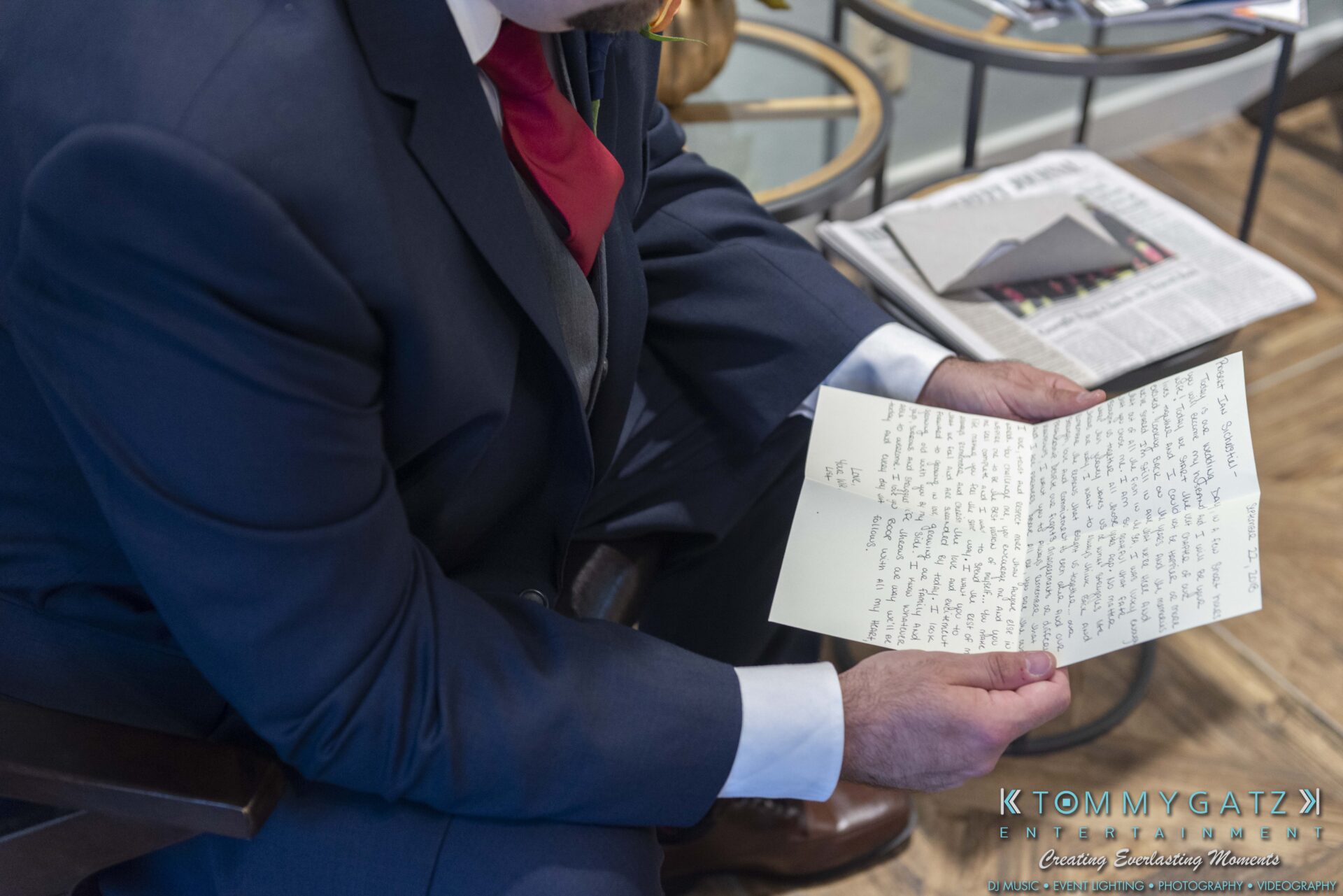 Lisa-Robert-092218-BLOG-selections-WM-25 - TOMMY GATZ ENTERTAINMENT A person in a suit is sitting and reading a handwritten letter with a newspaper on the table nearby.