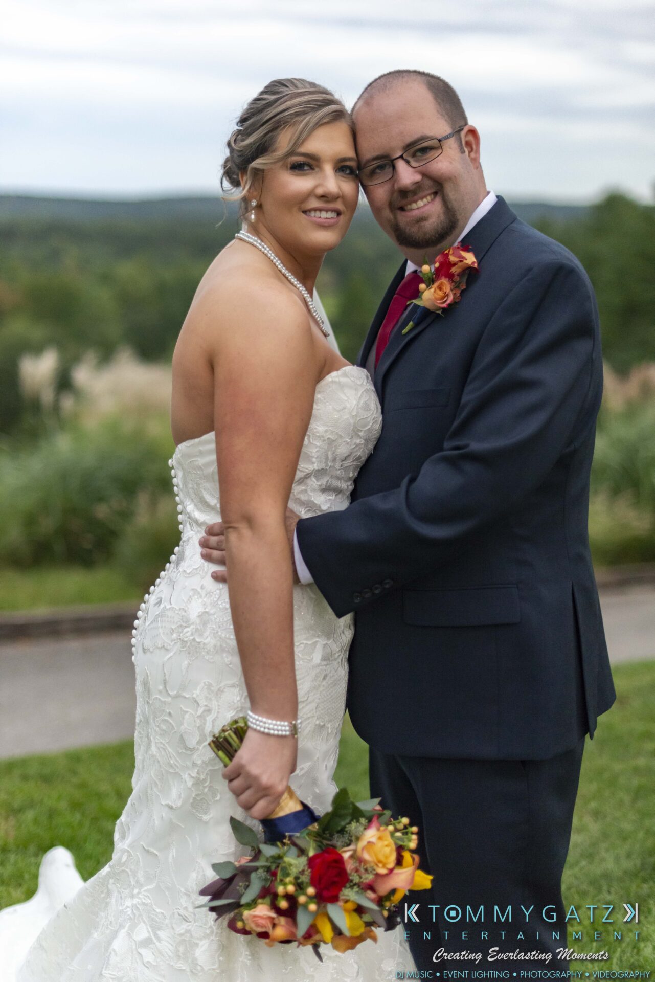 Lisa-Robert-092218-BLOG-selections-WM-75 - TOMMY GATZ ENTERTAINMENT A couple poses outdoors on their wedding day. The woman is in a white gown holding a bouquet, and the man is in a dark suit with a boutonniere.
