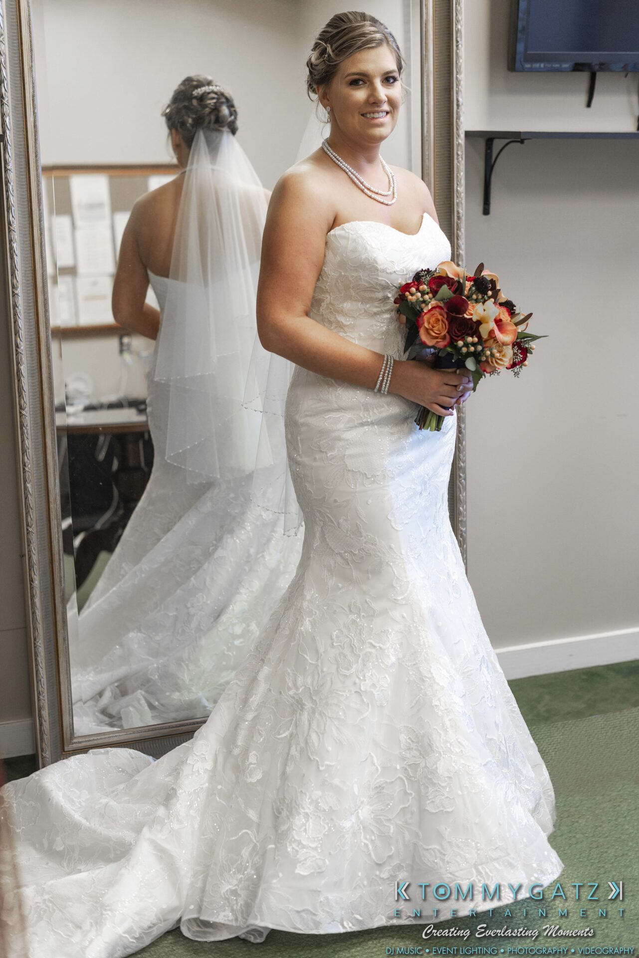 Lisa-Robert-092218-BLOG-selections-WM-9 - TOMMY GATZ ENTERTAINMENT A bride in a white strapless wedding dress holds a bouquet and stands in front of a mirror, with her reflection visible.