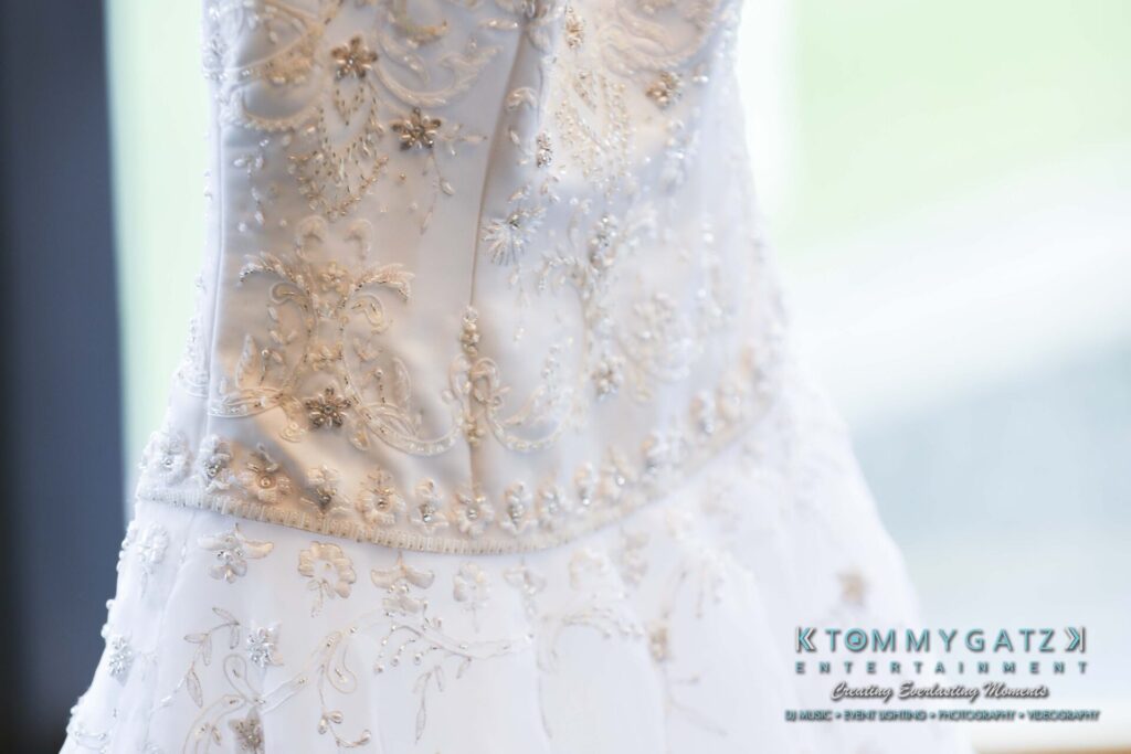 Close-up of an intricately embroidered white wedding gown bodice with delicate floral patterns and beadwork.