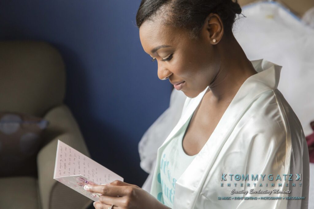 A woman in a white robe reads a handwritten card while sitting on a couch.