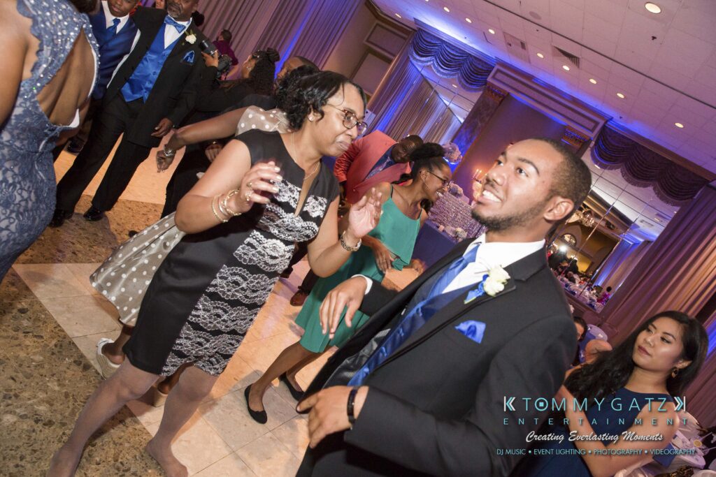 People dancing at an event, wearing formal attire.
