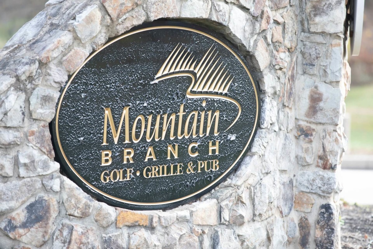 Scarlett-Michael-Wedding-Low-Res-1 - TOMMY GATZ ENTERTAINMENT Sign for Mountain Branch Golf Grille & Pub embedded in a stone structure.