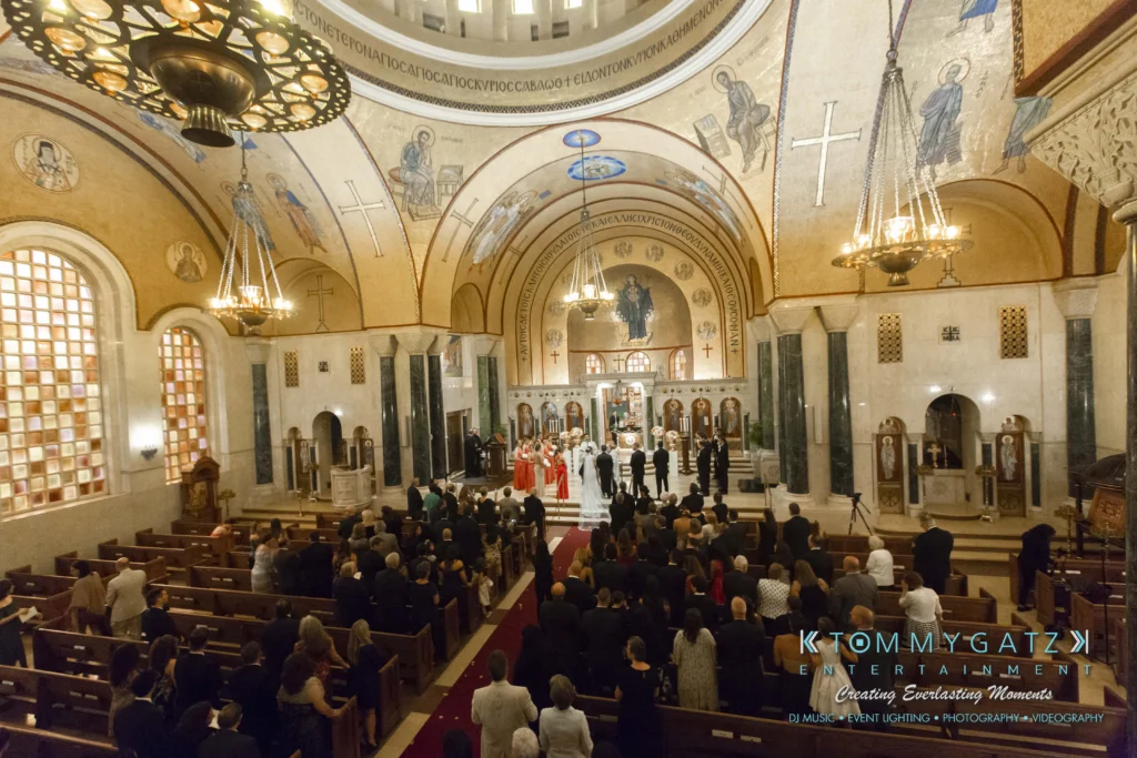 A large, ornate church interior hosts a wedding ceremony with a bride, groom, and guests seated in pews.