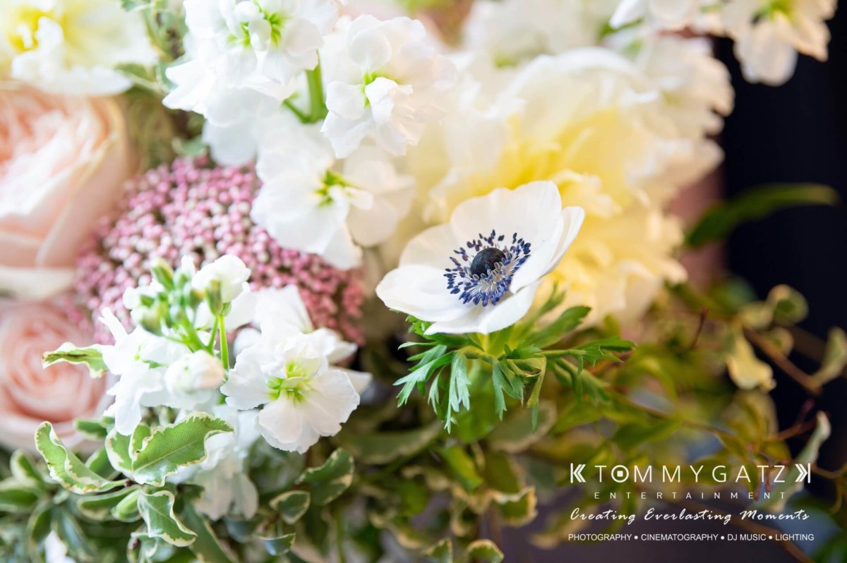 BrittanyDaniel-WEDDING-Highlights-32 - TOMMY GATZ ENTERTAINMENT A close-up of a detailed floral arrangement featuring pink roses, white anemones, and various greenery.