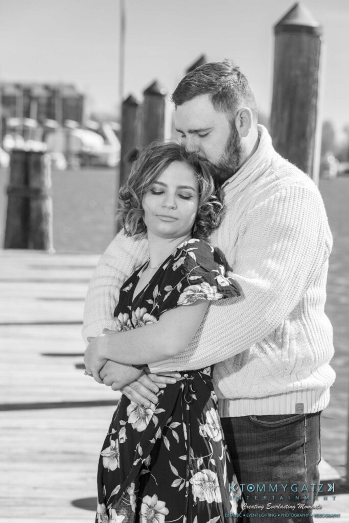 Shannon-James-031319-FINALS-Low-Res-WM-18 - TOMMY GATZ ENTERTAINMENT A person embraces another with closed eyes on a pier with water and wooden posts in the background.