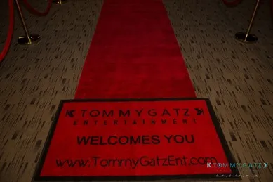 Red carpet with "Tommy Gatz Entertainment Welcomes You" written on a mat.