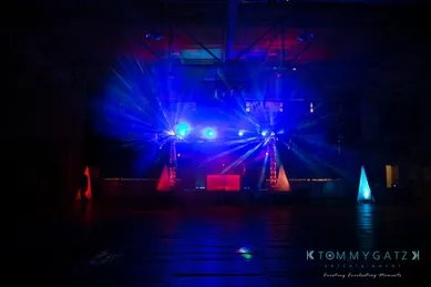 A dark room with blue and red stage lights shining, creating beam effects.