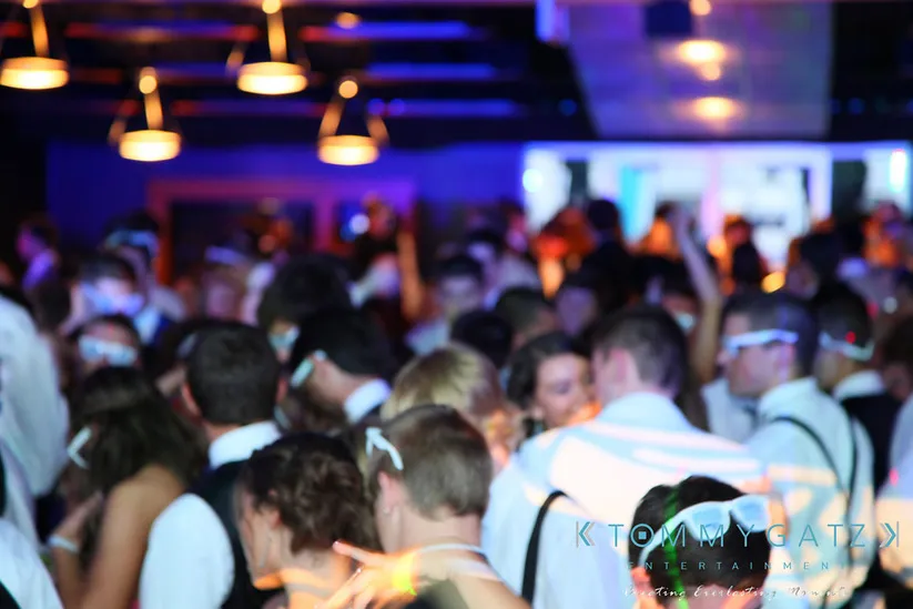 A blurry image of people dancing closely in a dimly lit party setting.
