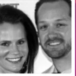 A black and white photo of a woman and a man smiling closely at the camera.