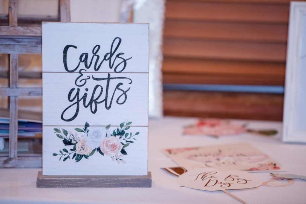 Christine-Jon-Wedding-Blog-94 - TOMMY GATZ ENTERTAINMENT A wooden sign on a table reads "Cards & gifts" with floral decoration. Nearby are cards and a circular tag with "The Big Day" text.