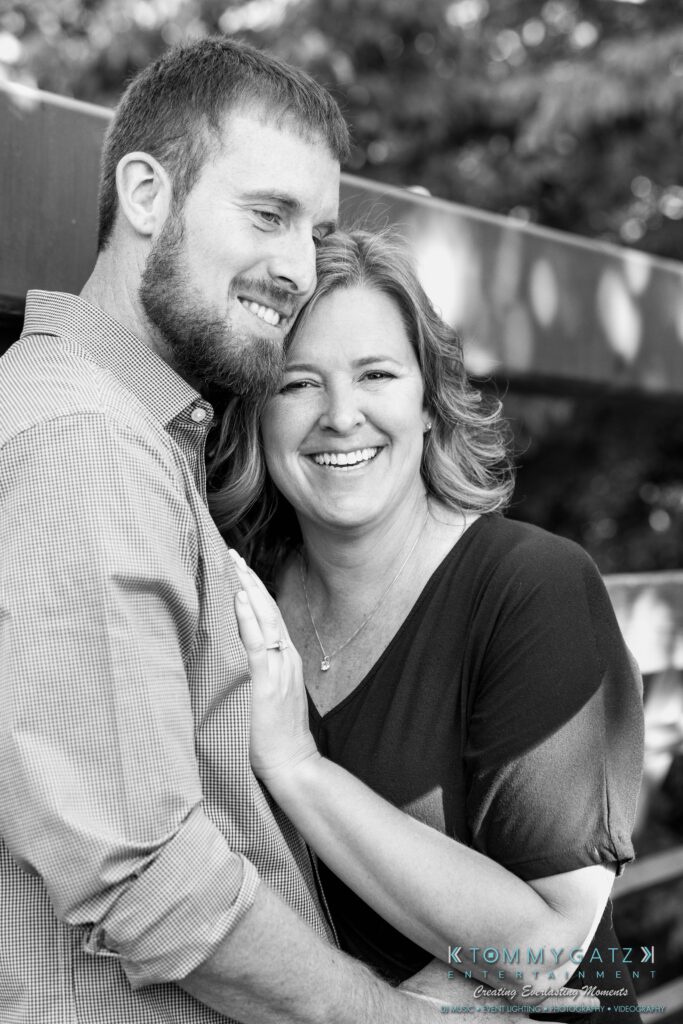 Heather-Scott-Engagement-Shoot-Low-Res-WM-13 - TOMMY GATZ ENTERTAINMENT A man and woman smiling while embracing outdoors.