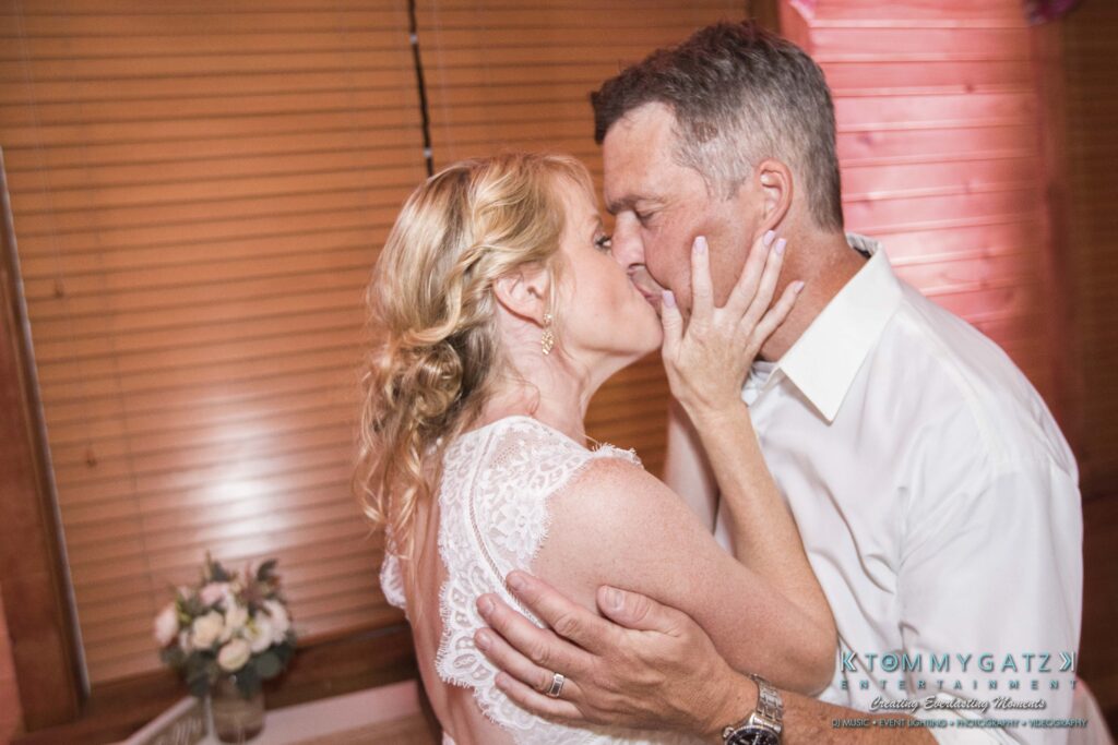 JenniferRudiWeddingReceptionPhotos-391 - TOMMY GATZ ENTERTAINMENT A couple embracing closely in a romantic dance, with the woman in a white dress.