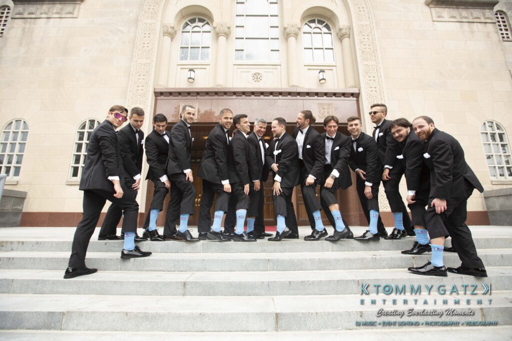 A group of men in suits stand on church steps, showing off colorful socks.